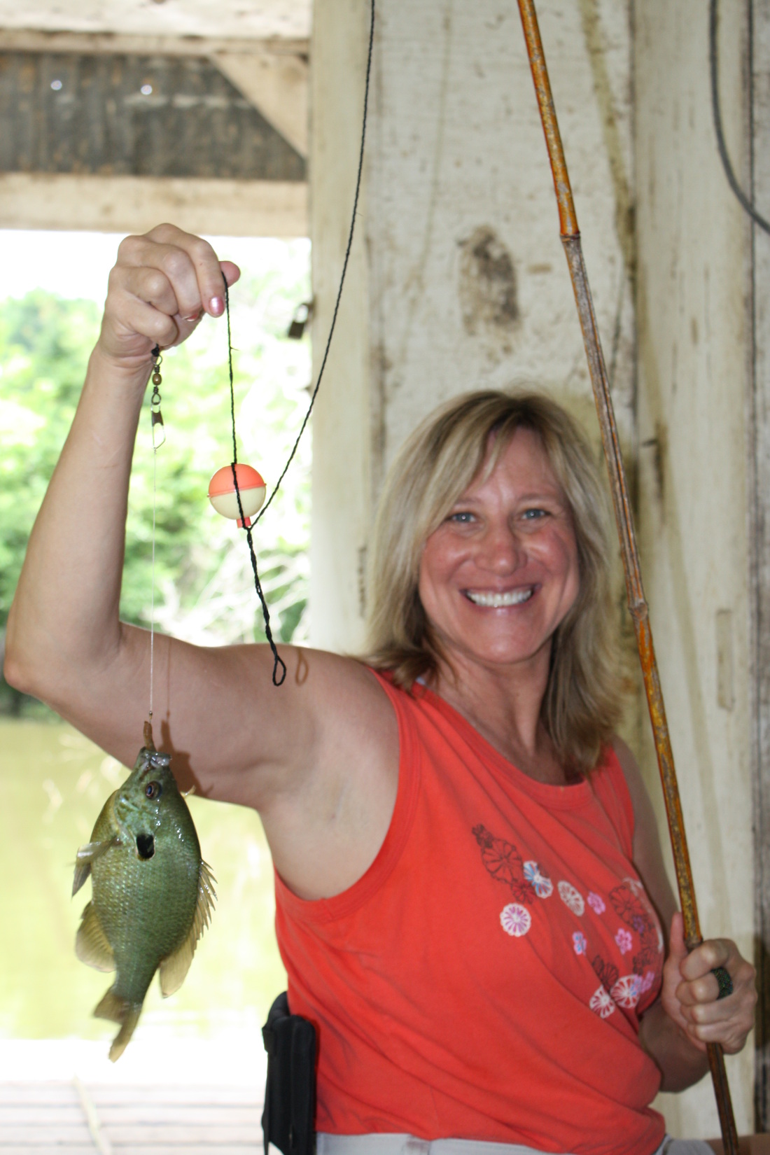 A blond woman holding a large bluegill